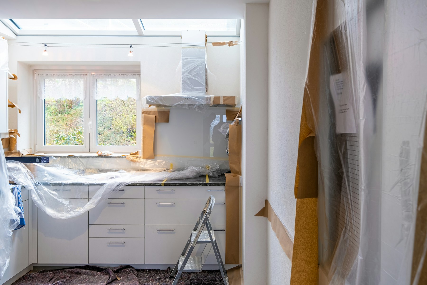 Installer mounting new white cabinets in a Tampa kitchen
